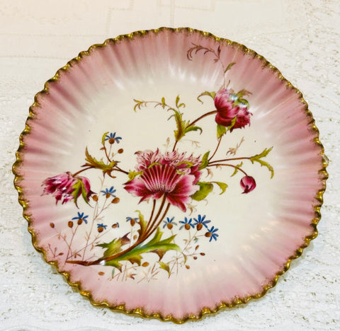 A beautiful vintage hand plate made by Carlton Ware.  The plate has a matt surface overpainted with a glossy botanical floral spray.  The colour is raspberry pink fading into an inner circle of cream.  The edges are ribbed with a band of gold.  The diameter is 8 3/4" (22cm).  Overall very good condition.  