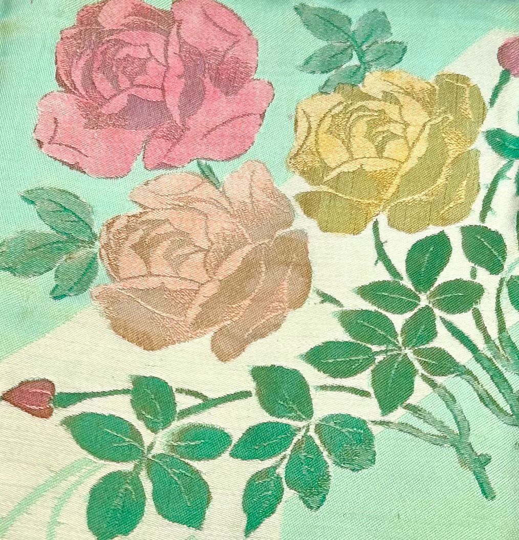 Original - Never Used.  A beautiful eye catching hand coloured tablecloth in bright bold colours. Green base colour decorated with large pink and yellow roses.  Size: 54” x 54”  Colour: Green Hand coloured roses made in Ireland Quality Number 306 Condition: Very Good, As New, Never Used