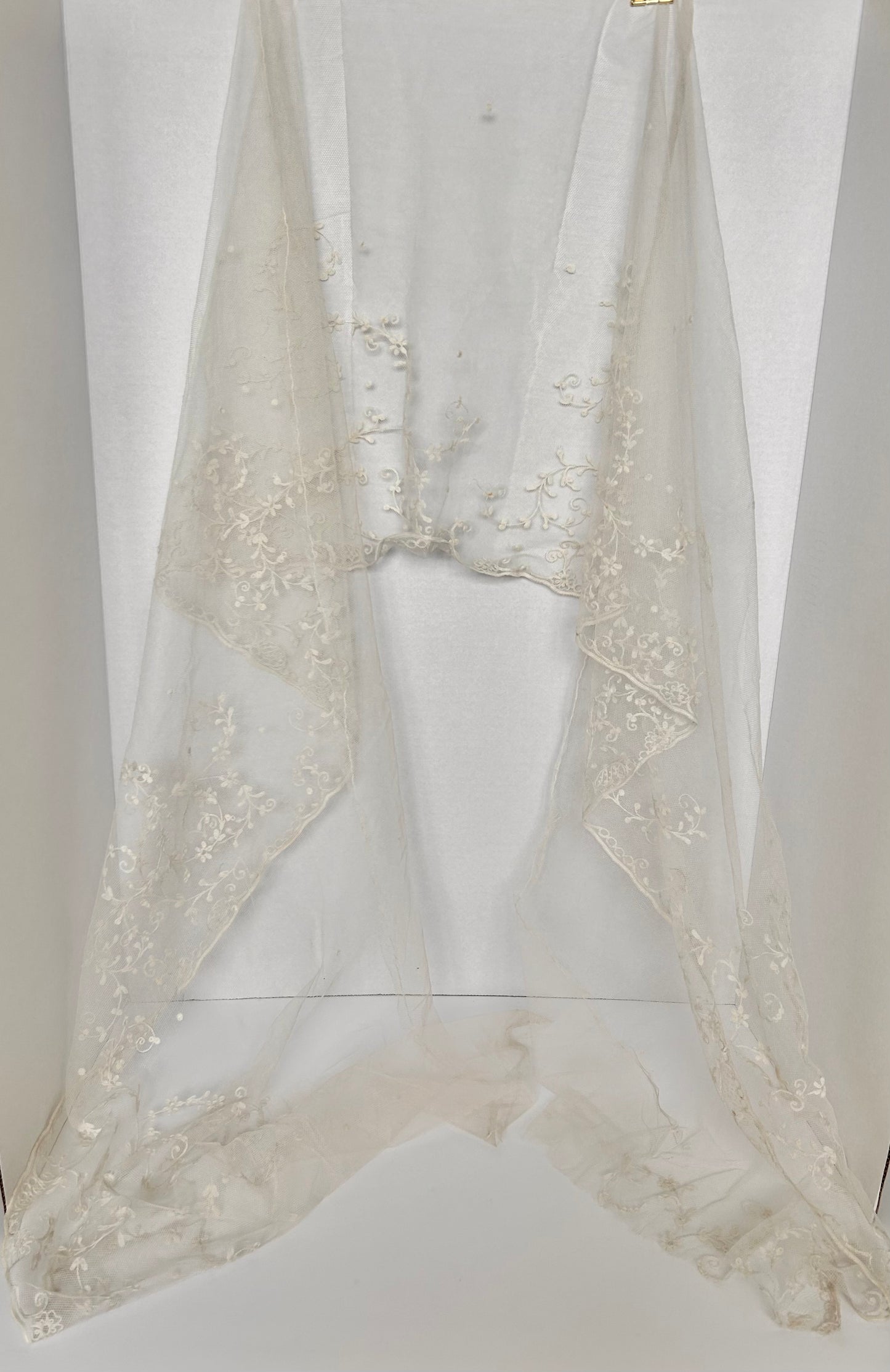 A vintage hand embroidered wedding flounce bridal veil on a mesh background.  Dimensions: &nbsp;266cm Length x 53 cm wide&nbsp;  A stunning and exquisite piece of bridal attire that exudes timeless elegance and romance. This delicate flounce is &nbsp;meticulously adorned with intricate embroidery and embellishments. Its purpose is to add a touch of ethereal beauty and sophistication to the wedding gown featuring &nbsp;intricate &nbsp;florals reminiscent of classic and vintage styles. 