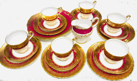 An elegant vintage tea set - tea cups and saucers. Made in England by New Chelsea China. &nbsp;Warm rich cranberry red with gold filigree. &nbsp;Vintage and pre loved. &nbsp;Very good condition, no damage, &nbsp;Standard size. &nbsp;The ilk jug is made by Tuscan China. &nbsp;  6 Tea cups&nbsp; 6 Saucers 6 Tea plates 1 Milk Jug